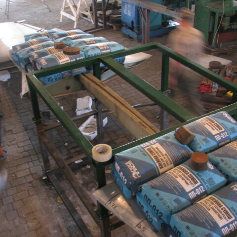 A table with many bags of blue cement on it