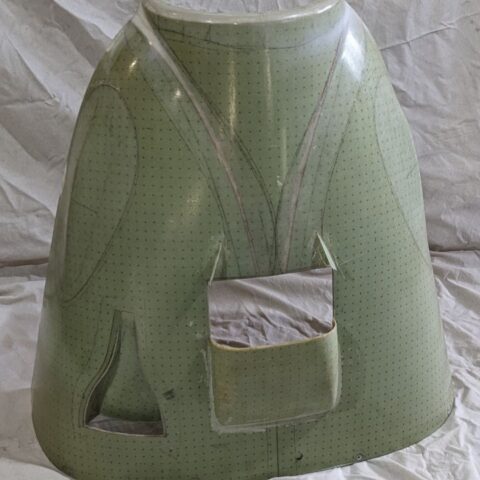 A green plastic helmet sitting on top of a bed.