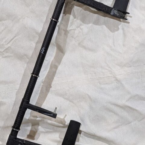 A black metal pole sitting on top of a white sheet.