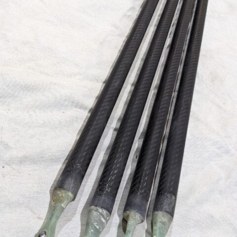 A group of four black rods sitting on top of a white surface.