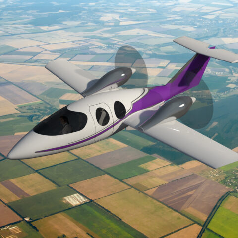 A purple and white plane flying over the grass.